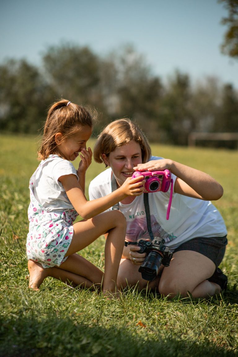 Sandra Neher und ein kleines Mädchen schauen sich die Bilder auf der Kamera des Mädchens an.