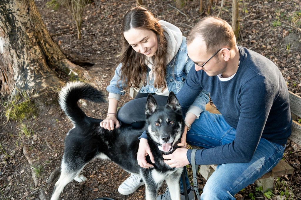 Ein Pärchen genießt den Moment mit ihrem Hund.