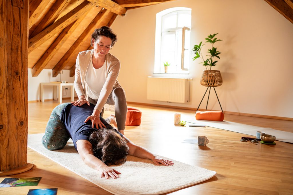 Personal Branding Fotografie im Einsatz: Eine Achtsamkeitslehrerin macht zusammen mit ihrer Klientin eine Yogaübung.