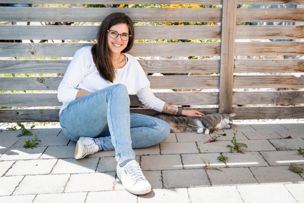 Personal Branding Fotografie für eine Tierkommunikatorin: Eine junge Frau streichelt ihre Katze und lacht glücklich.